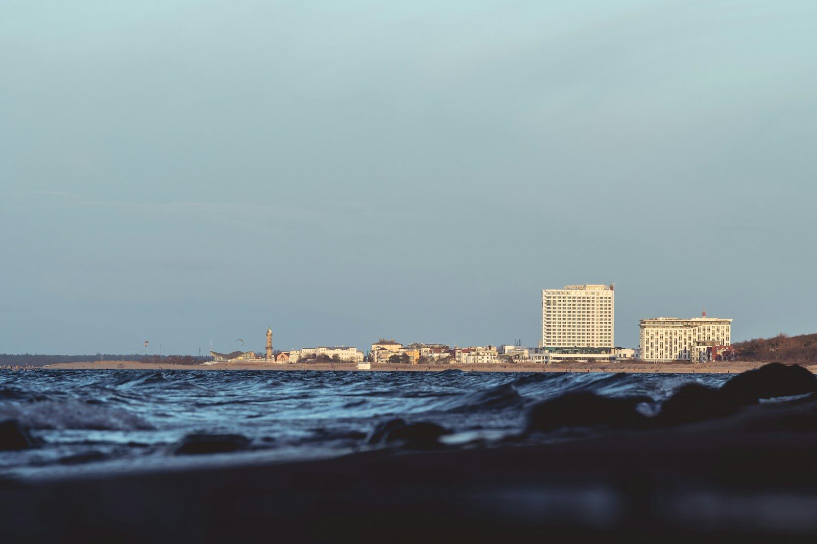 Ocean waves with buildings in the distance